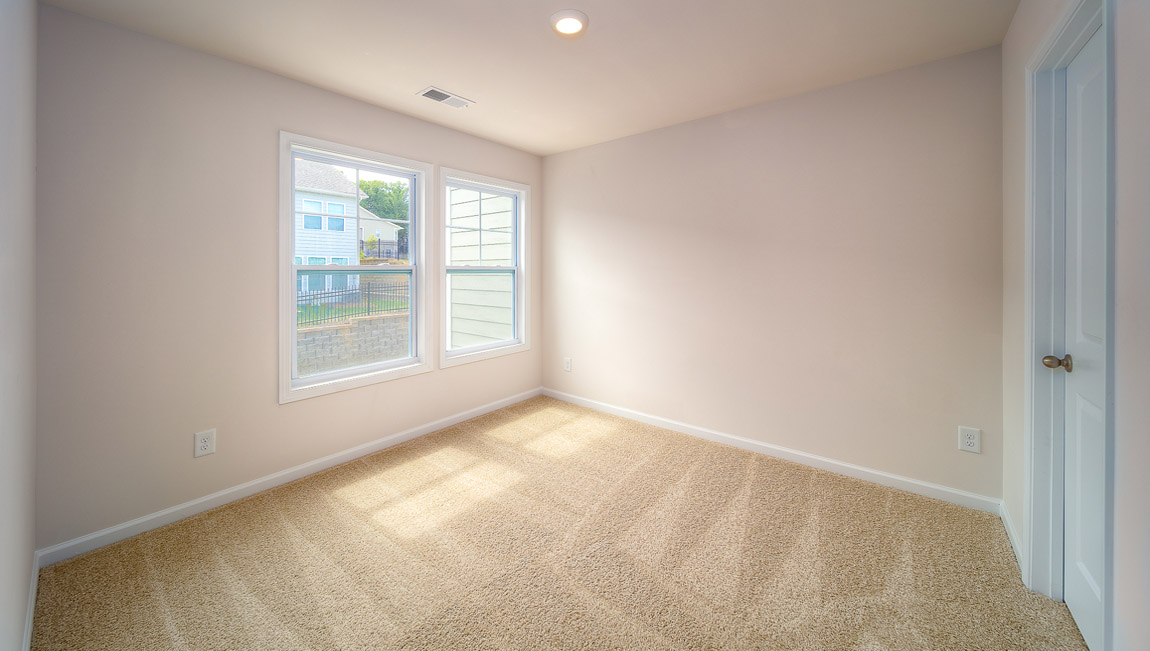 Carpeted bedroom with large windows