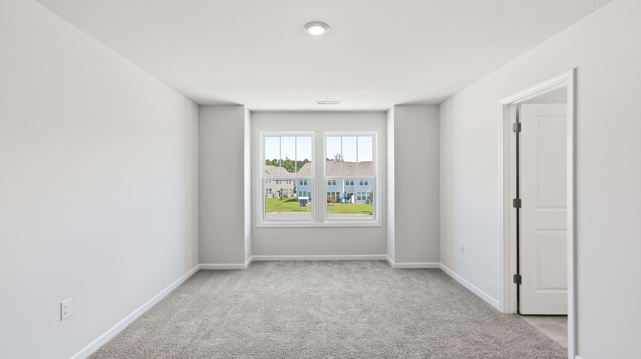 Primary bedroom with large windows and attached bathroom