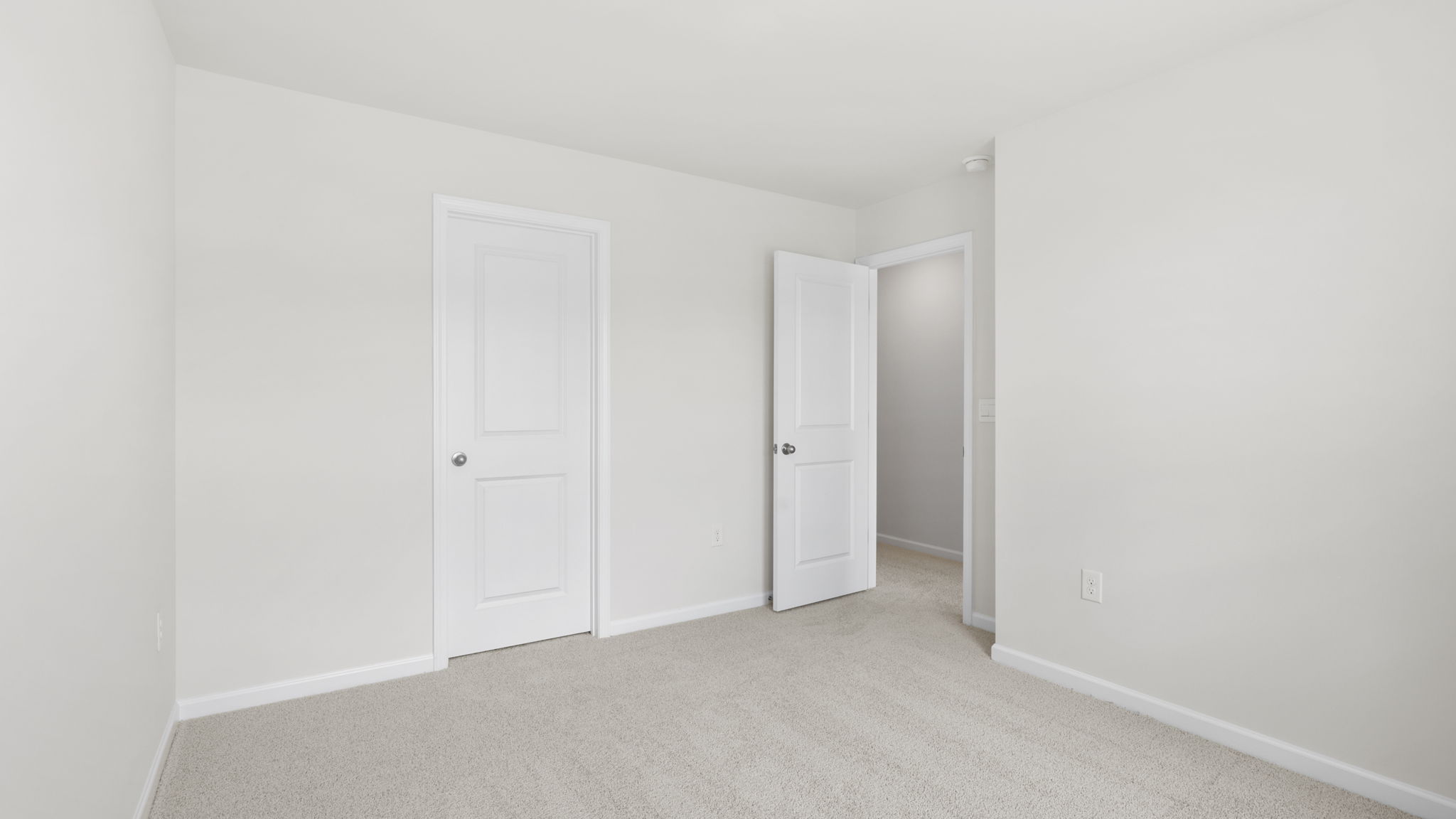 Carpeted bedroom with view of hallway