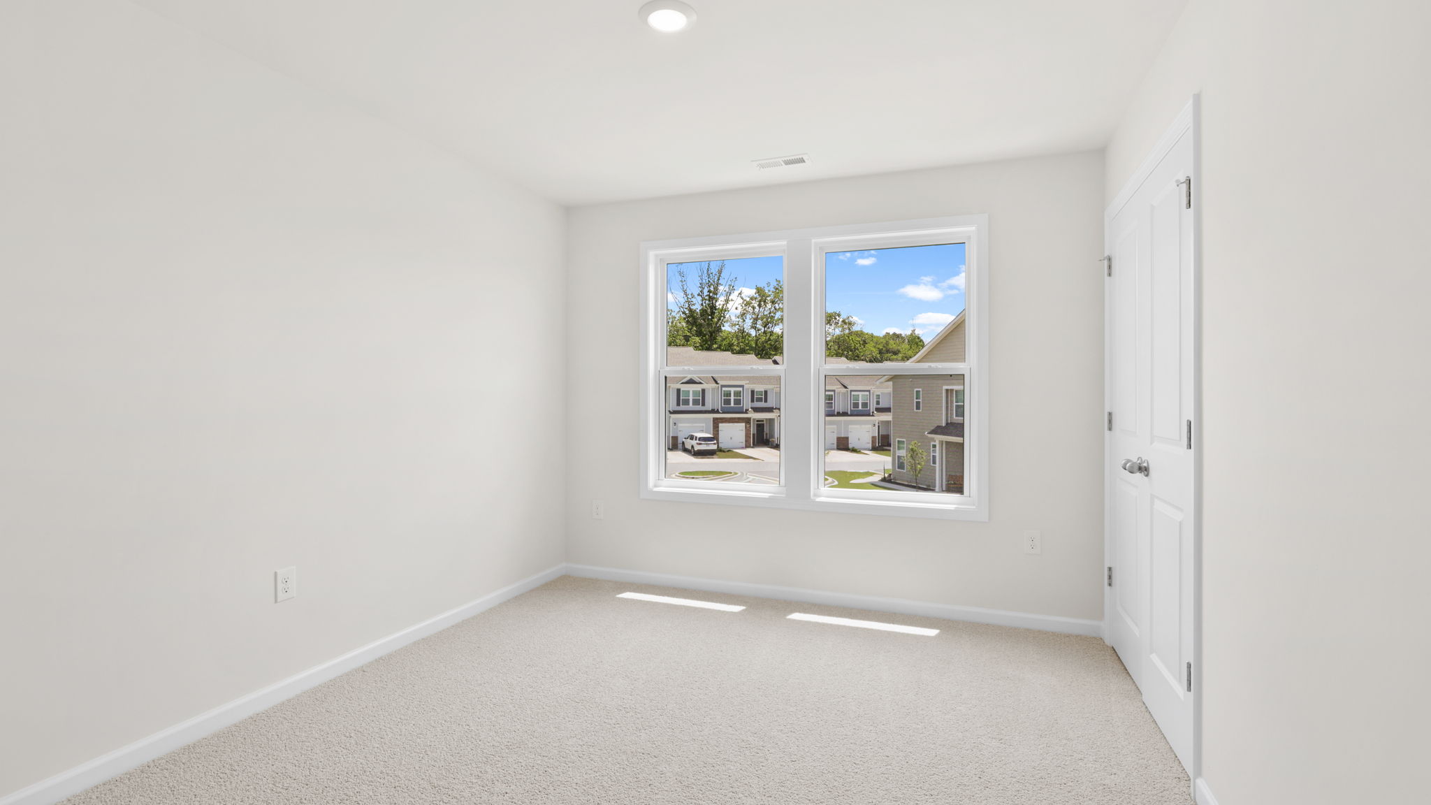 Carpeted bedroom with large windows