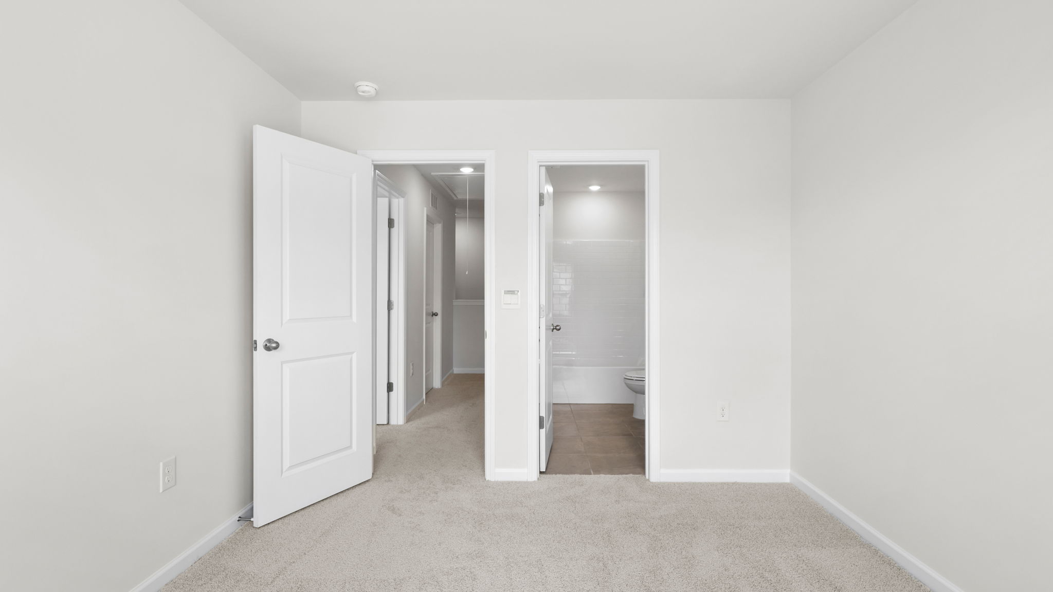 Carpeted bedroom with view of hallway