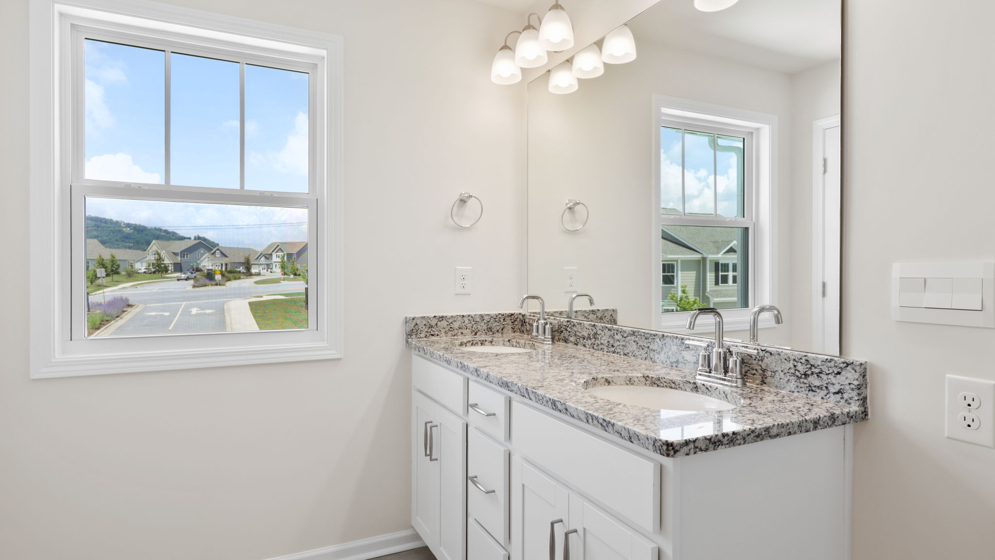 Primary bathroom with dual vanity and large window
