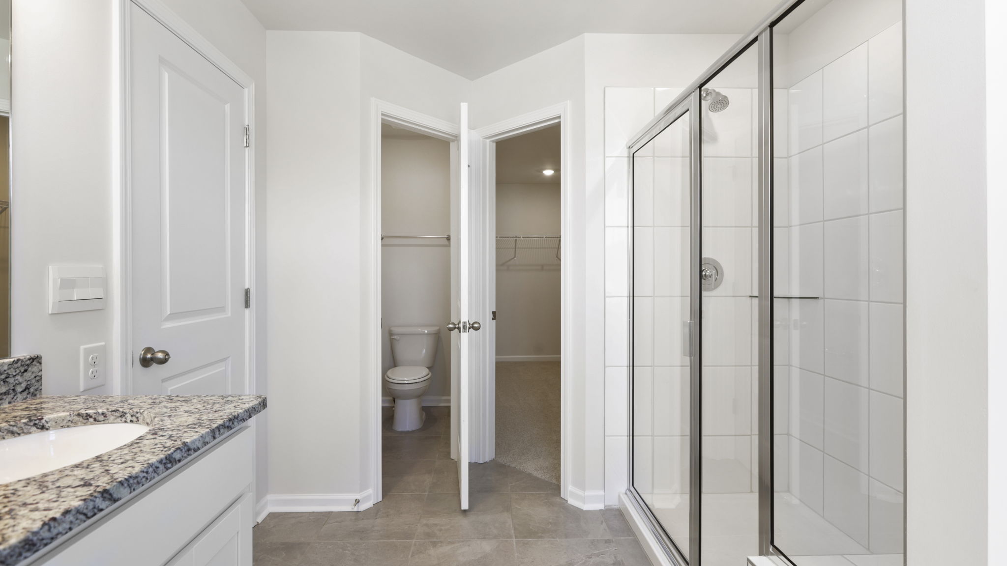 Primary bathroom with dual vanity and walk in shower with glass doors