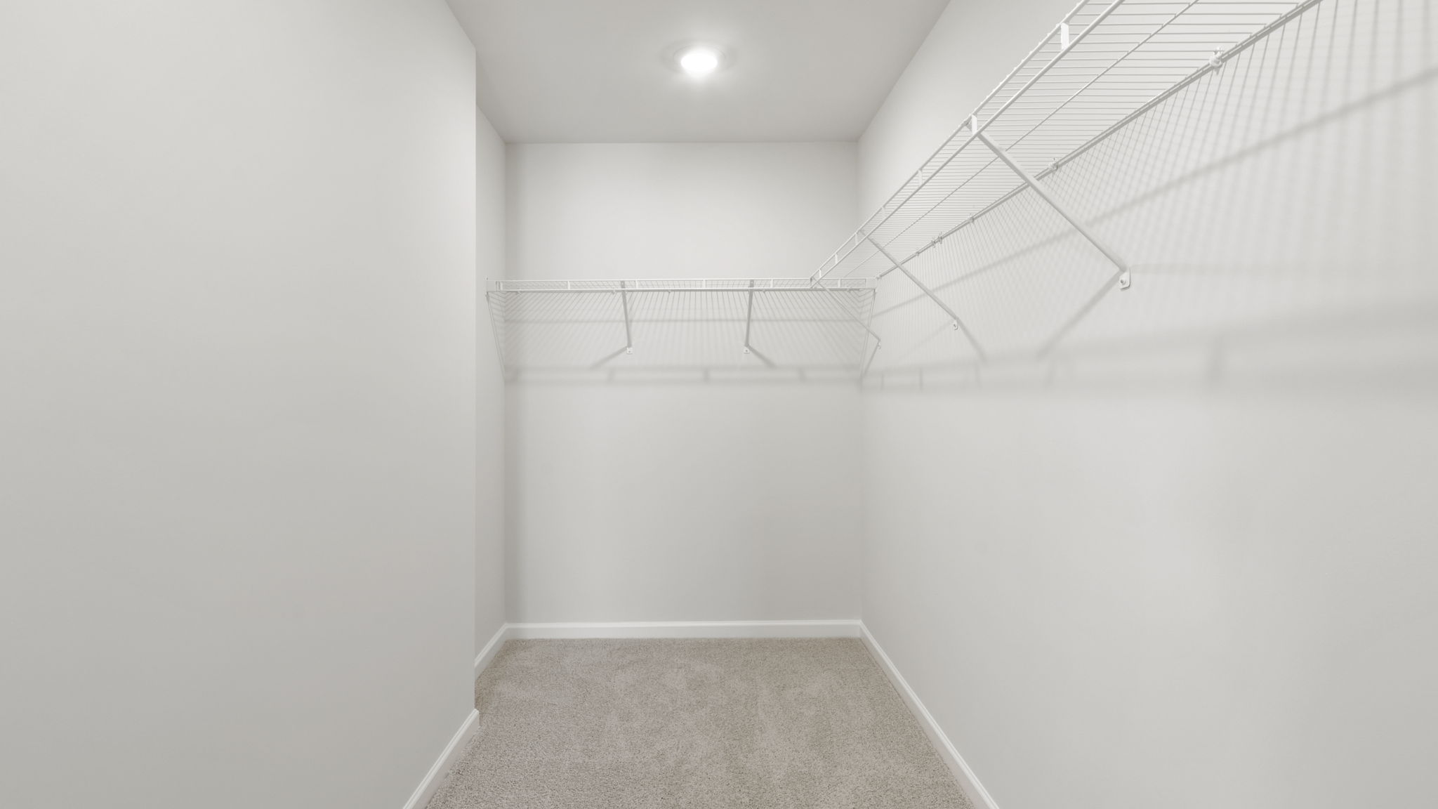 Primary walk in closet with shelving