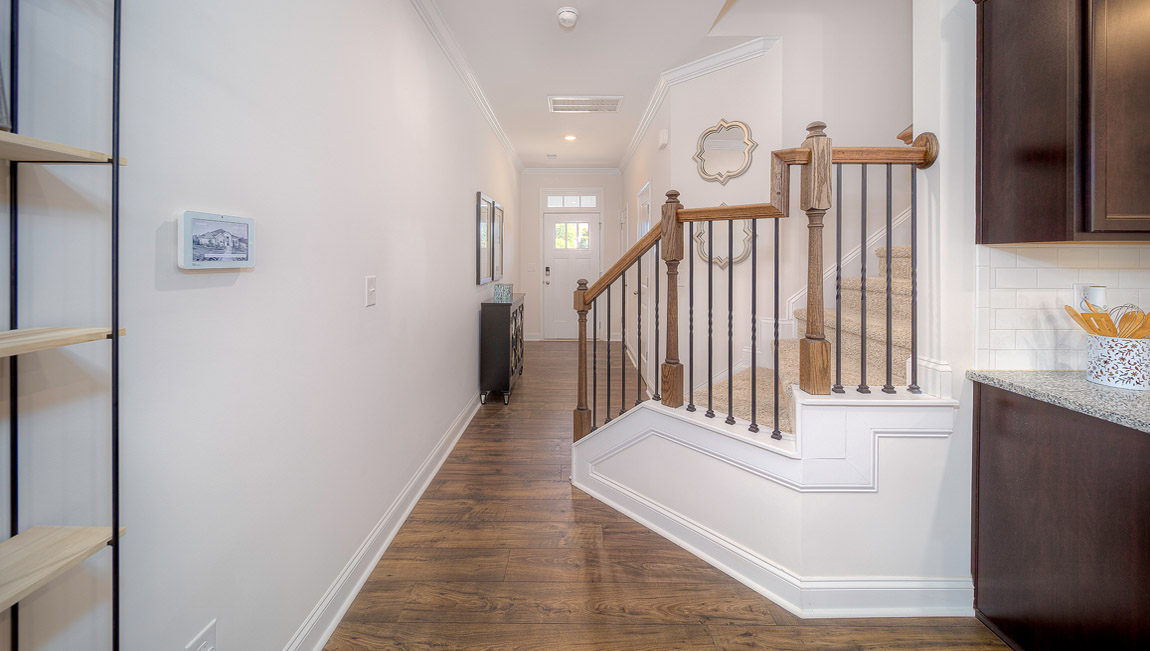Welcoming foyer with wood floors, and view of staircase and front door