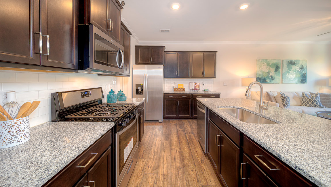 Kitchen and island with brown cabinets, and stainless steel appliances