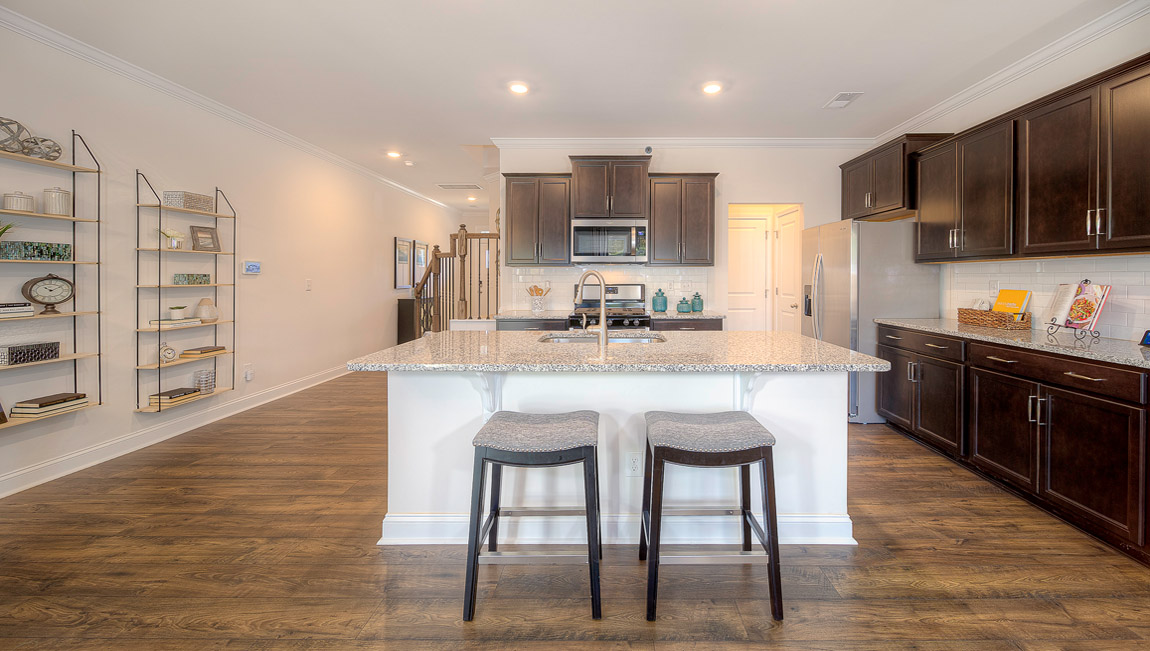 Kitchen and island with brown cabinets, and stainless steel appliances