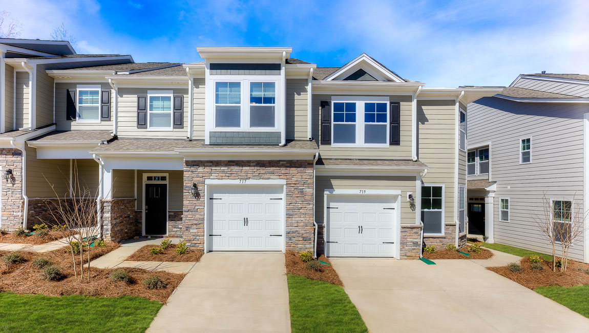 Lansing fron exterior with stone and beige siding and one car garage