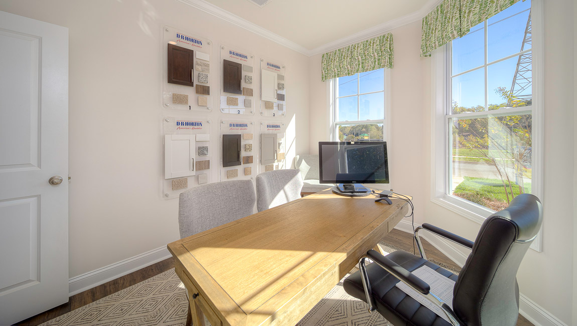 Den area with three large windows and wood foors