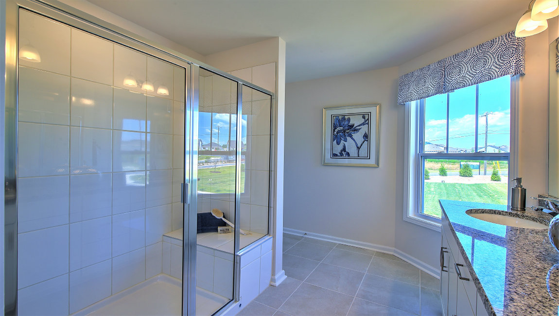 Primary bedroom with dual vanity and walk in shower