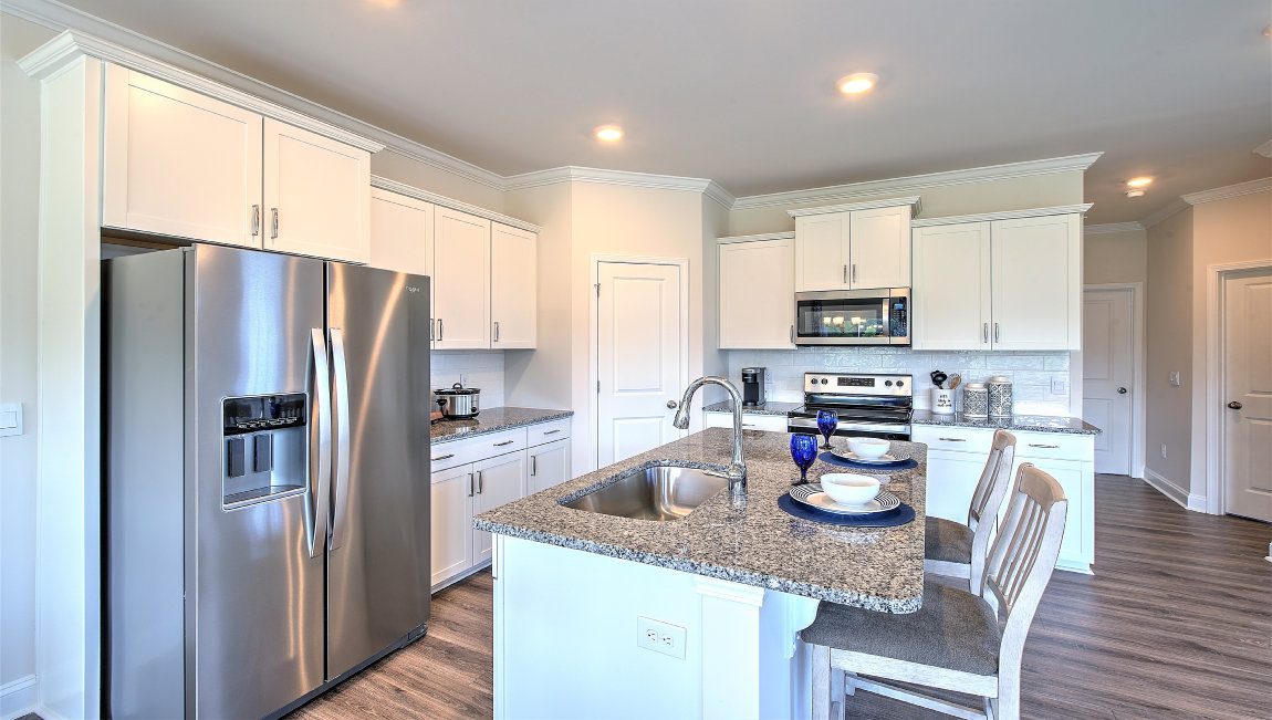 Open concept kitchen with stainless-steel appliances and large island