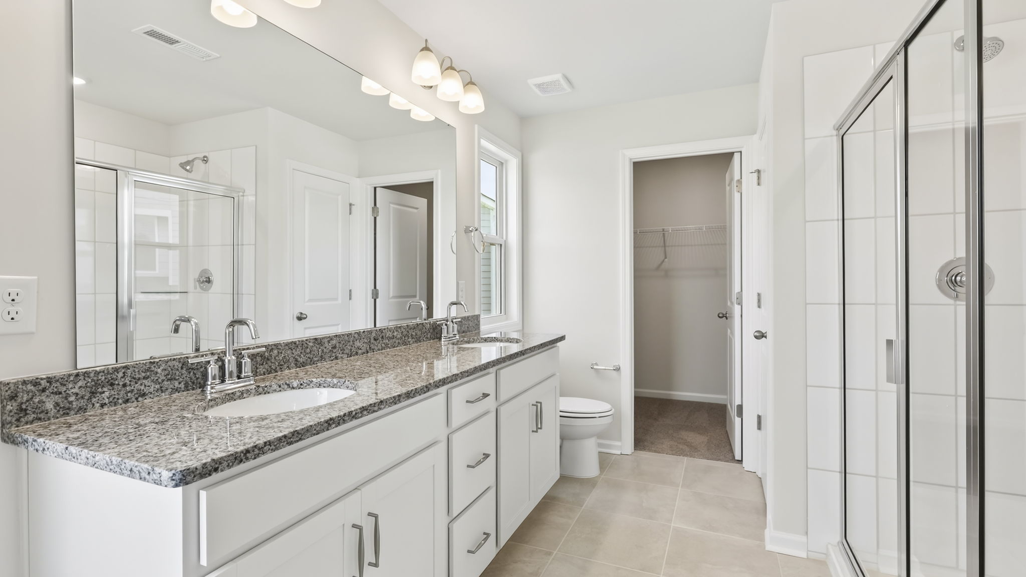 Primary bathroom with dual vanity and walk in shower