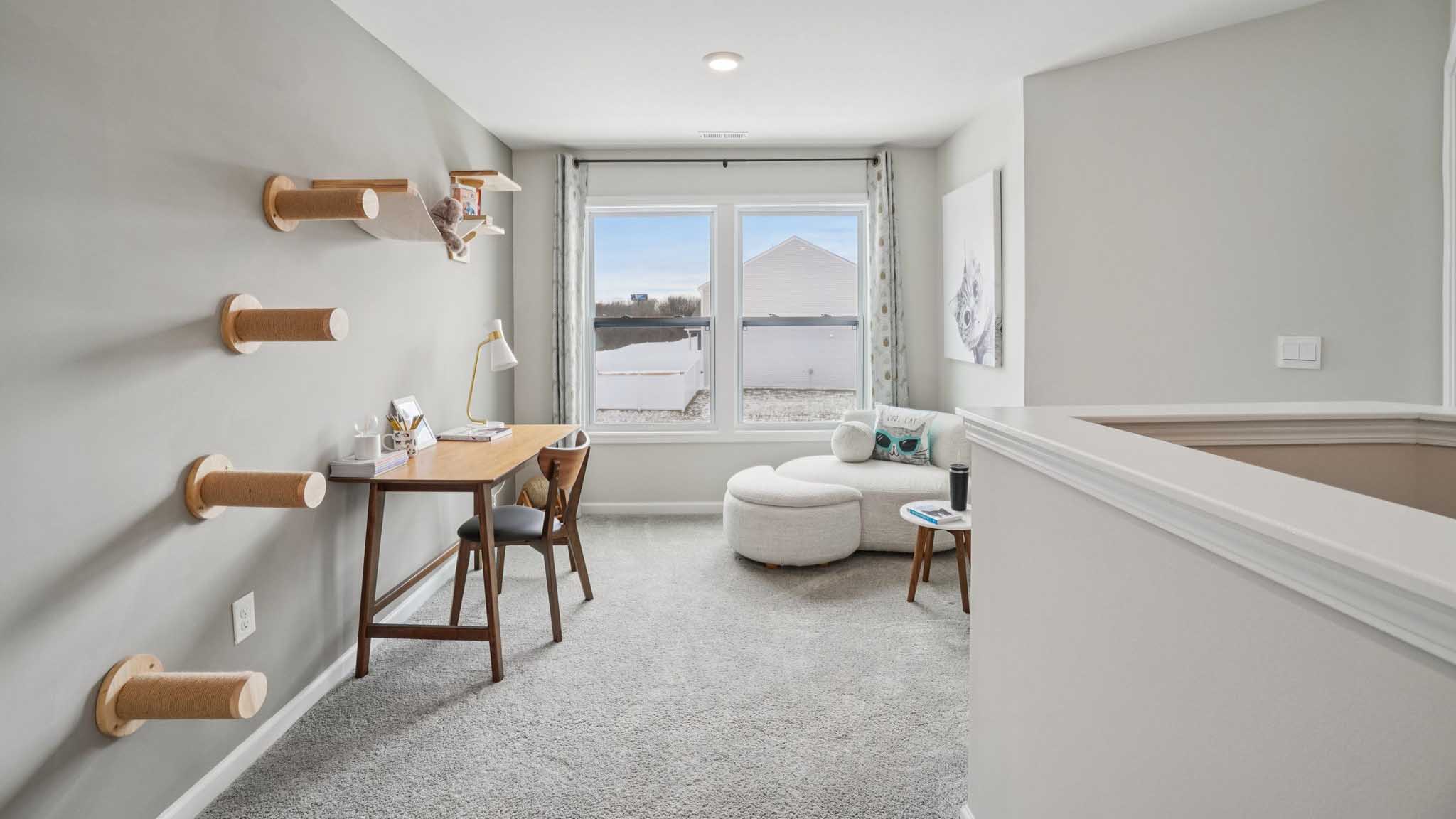 Carpeted upstairs loft with large windows