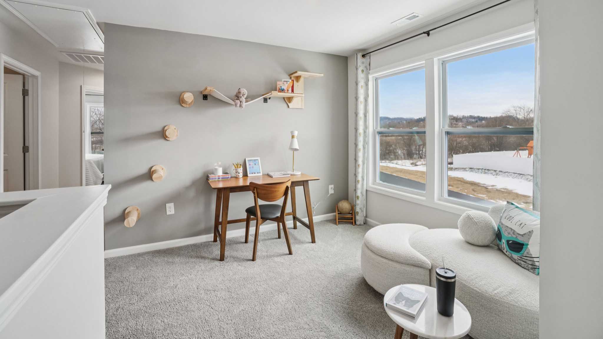 Carpeted upstairs loft with large windows