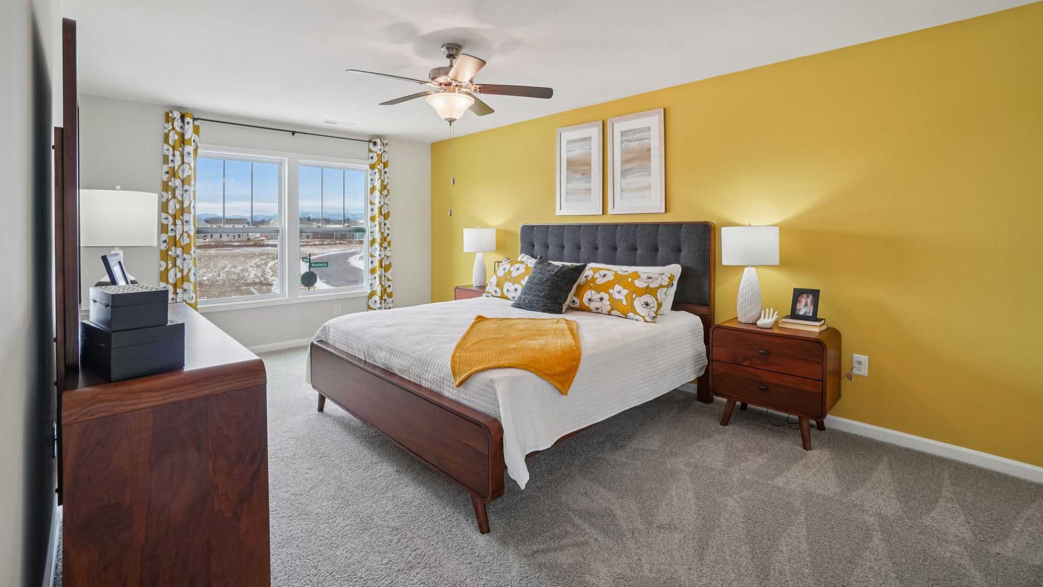 Carpeted primary bedroom with large windows