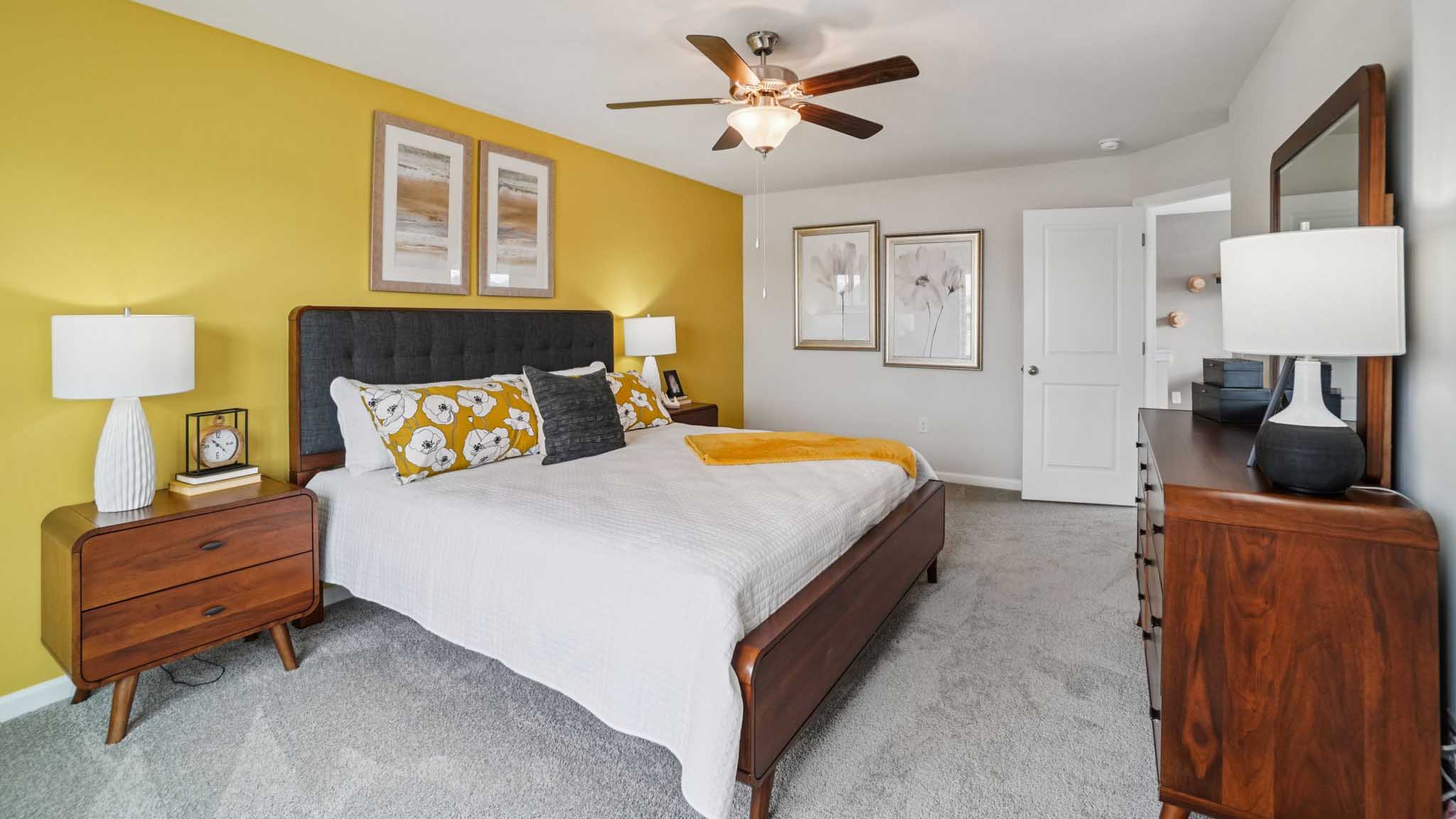 Carpeted primary bedroom with large windows