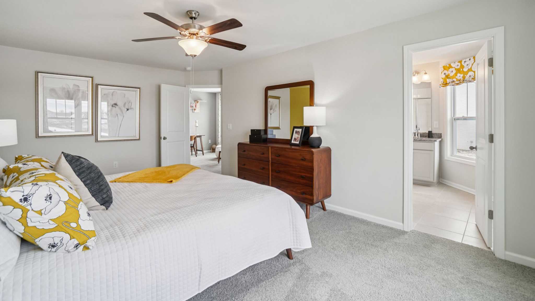 Carpeted primary bedroom with attached bathroom