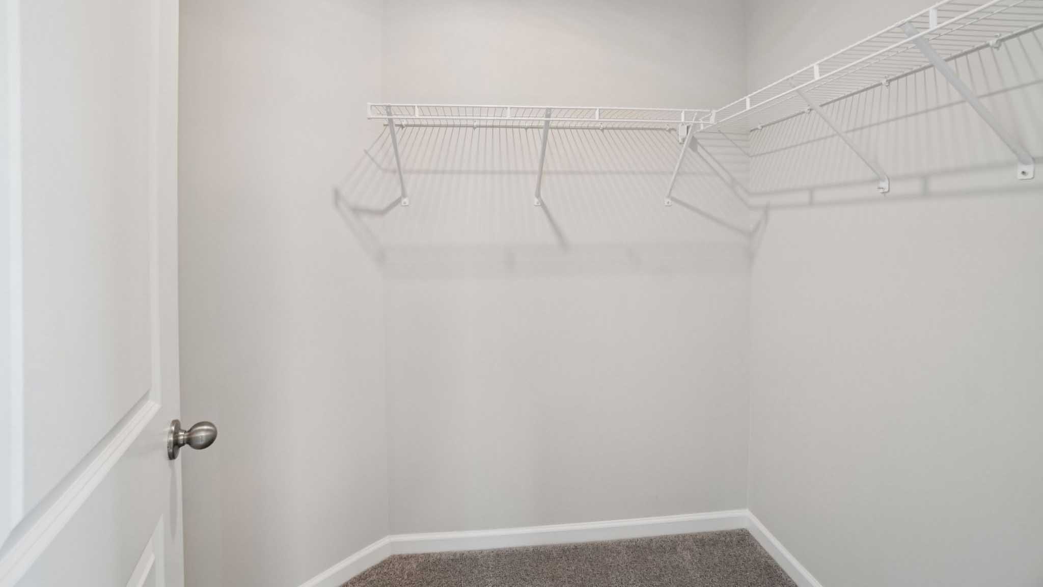 Primary walk in closet with shelving