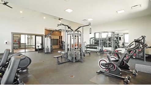 Spacious gym with several different types of equipment.