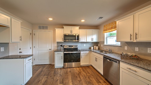 Kitchen with white cabinets, granite counters, and stainless steel appliances