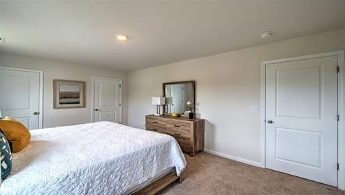 Carpeted bedroom with two small windows