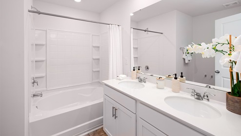 Primary bathroom with double sinks, and bathtub
