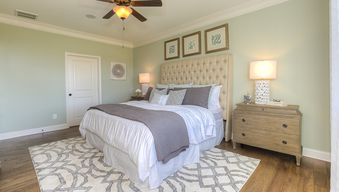 Primary bedroom with wood floors, and large window