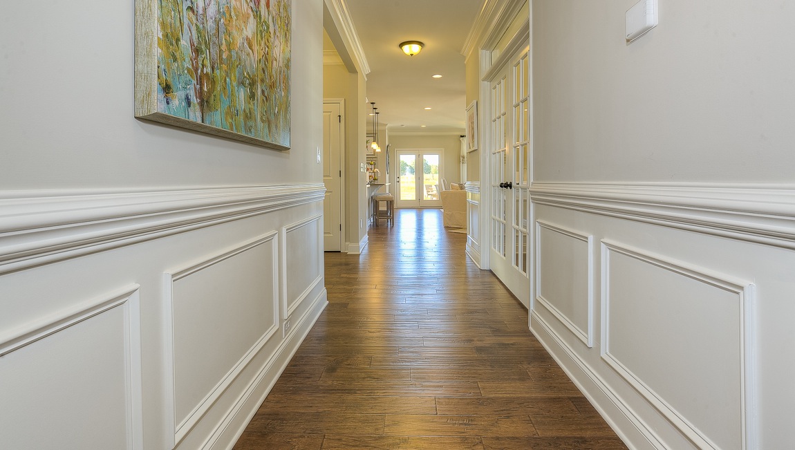Welcoming foyer with wood floors, view of french doors, front door and staircase