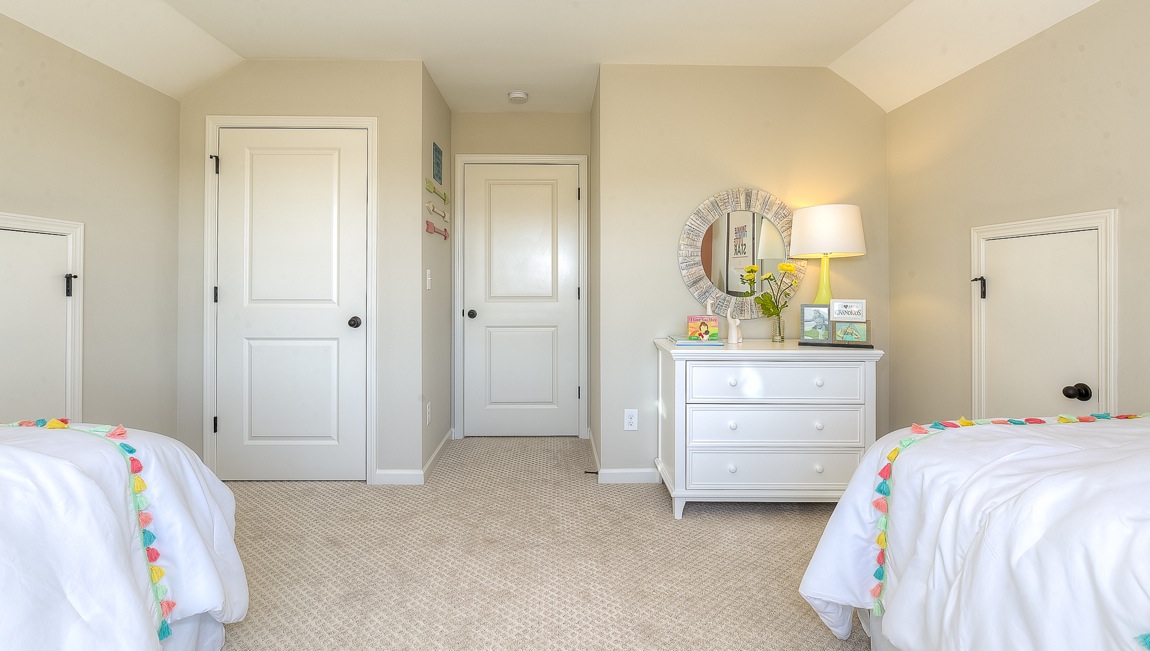 Large carpeted bedroom with large window