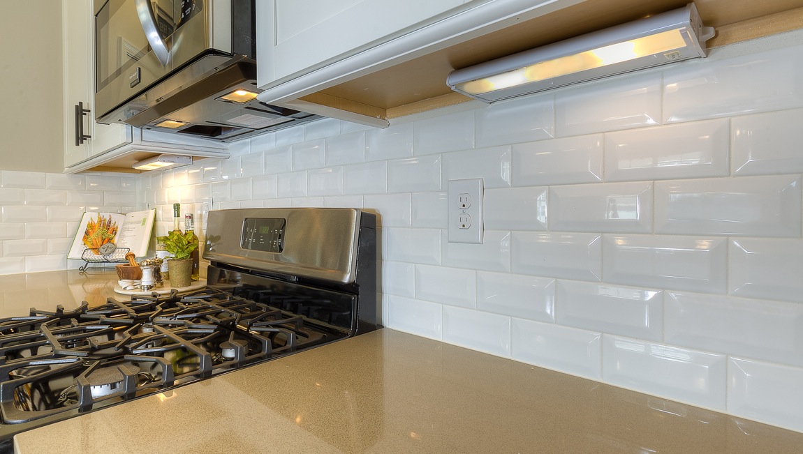 Kitchen and island with wood floors, white cabinets, breakfast area at island bar, and stainless steel appliances