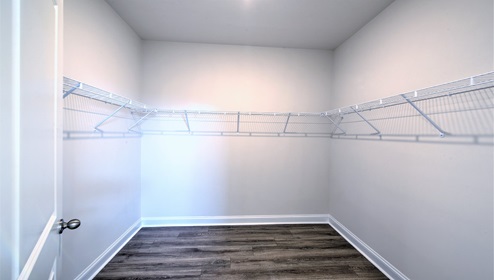 Walk in closet with wood floors