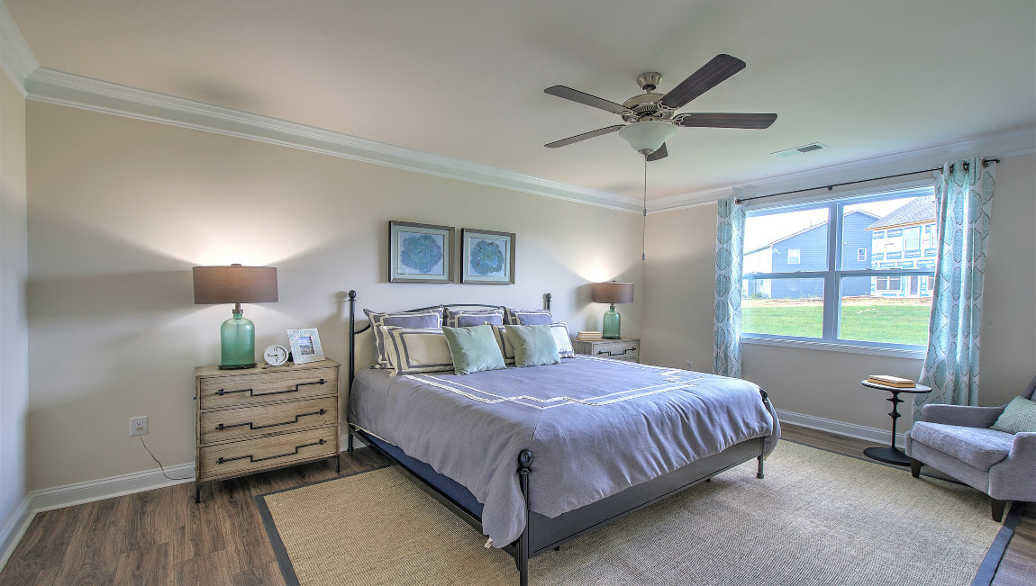 Bedroom with vinyl flooring, large window, and ceiling fan