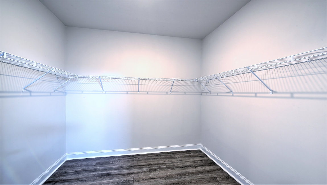 Walk in closet with vinyl flooring and racks
