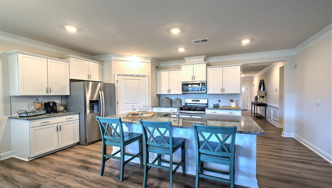 Kitchen and island, white cabinets, and stainless steel appliances