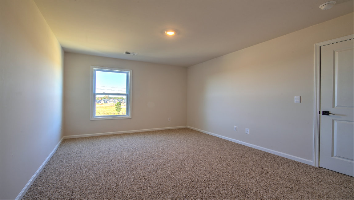 Carpeted bedroom with two large windows