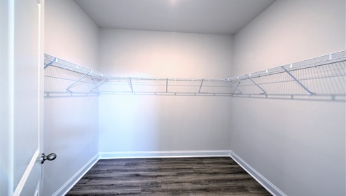 Walk in closet with vinyl flooring and racks