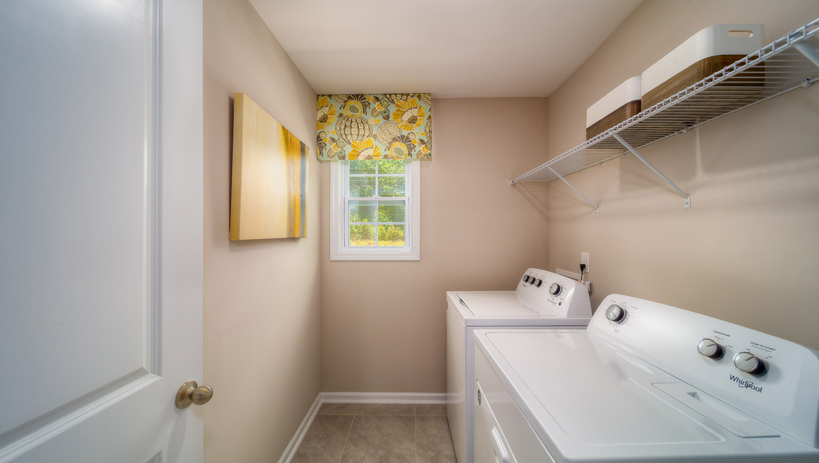 Laundry room with built in racks above machines