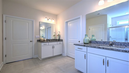 Bathroom with two counters and sinks, glass door shower