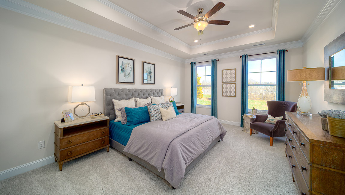 Primary bedroom with carpet, and two large windows
