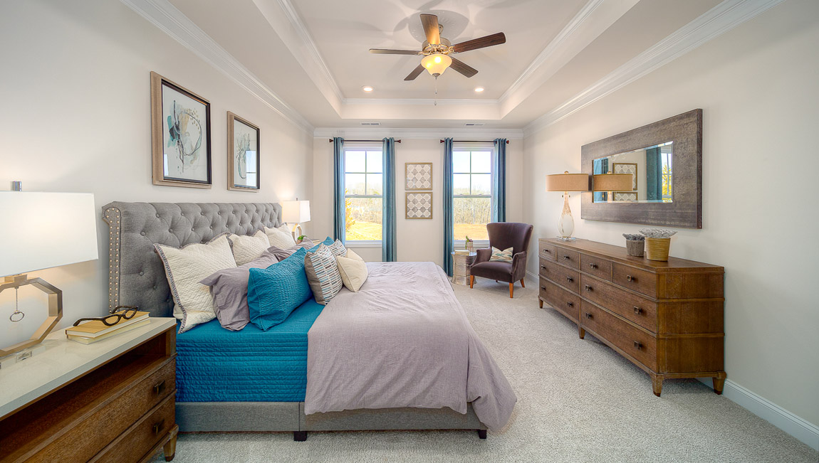 Primary bedroom with carpet, and two large windows