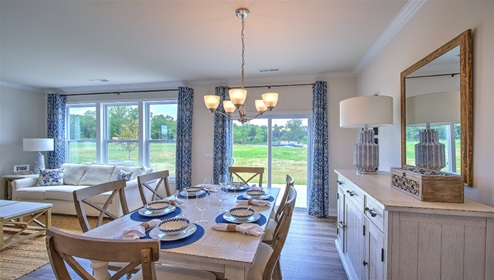 Dining area next to kitchen, large windows