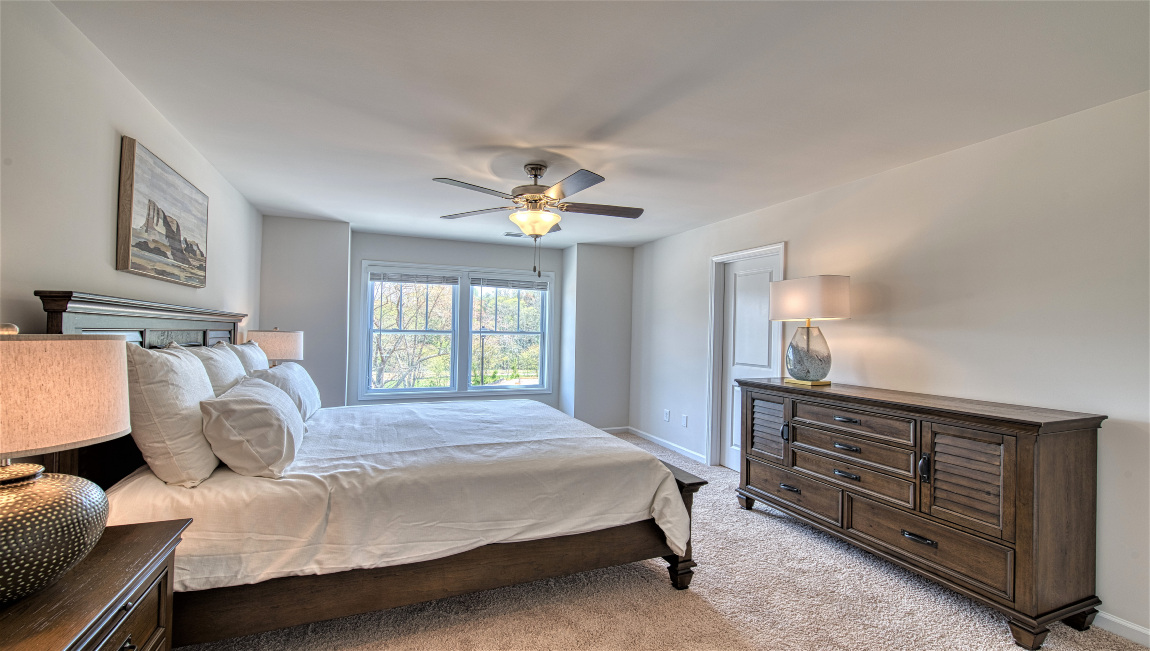 Carpeted primary suite with two large windows