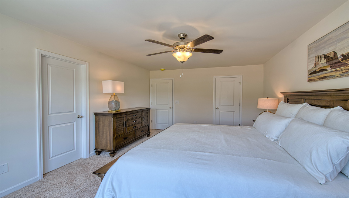 Carpeted primary suite with two large windows