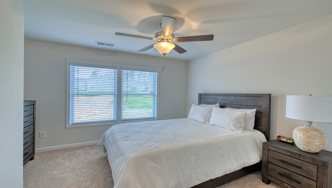 Carpeted bedroom with two small windows
