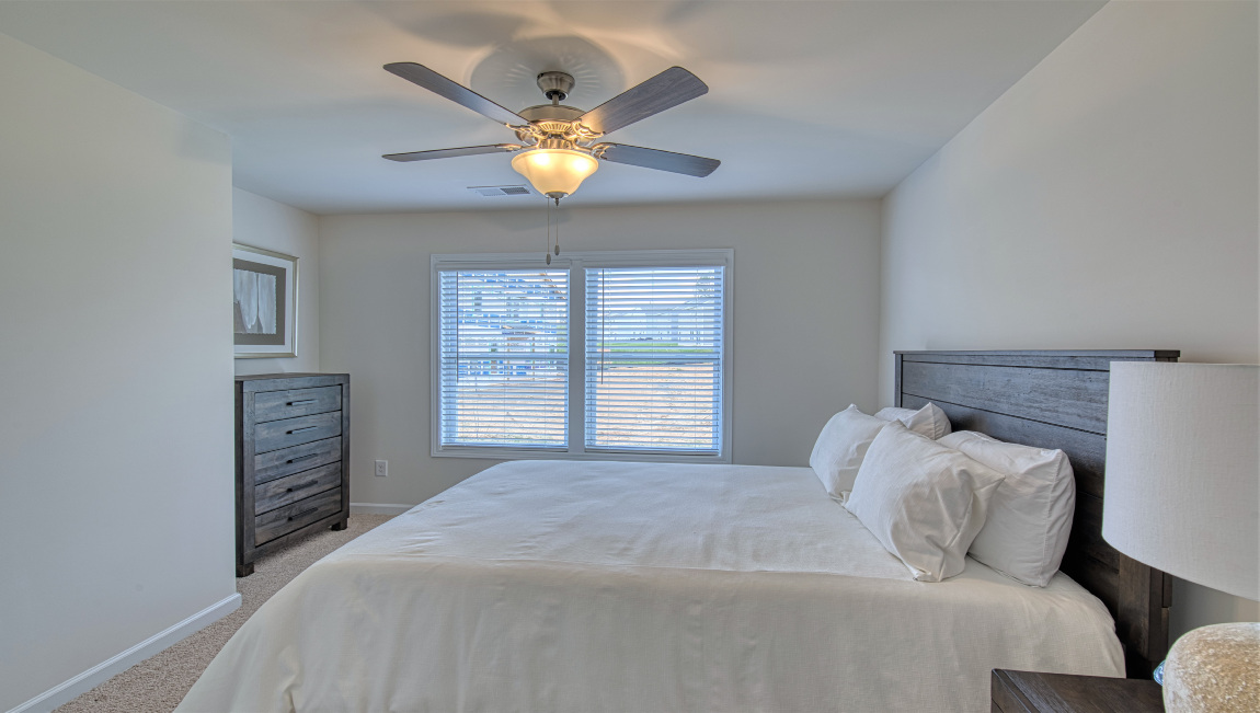 Carpeted bedroom with two small windows