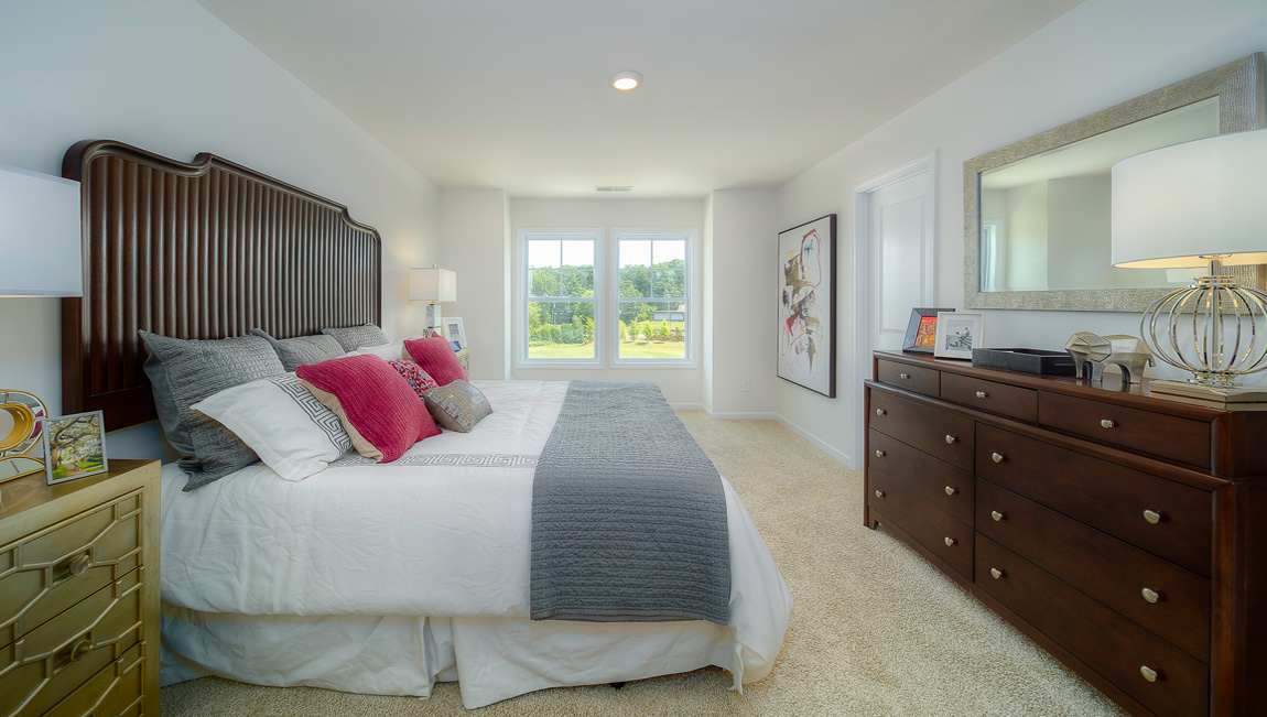 Carpeted primary suite with two large windows