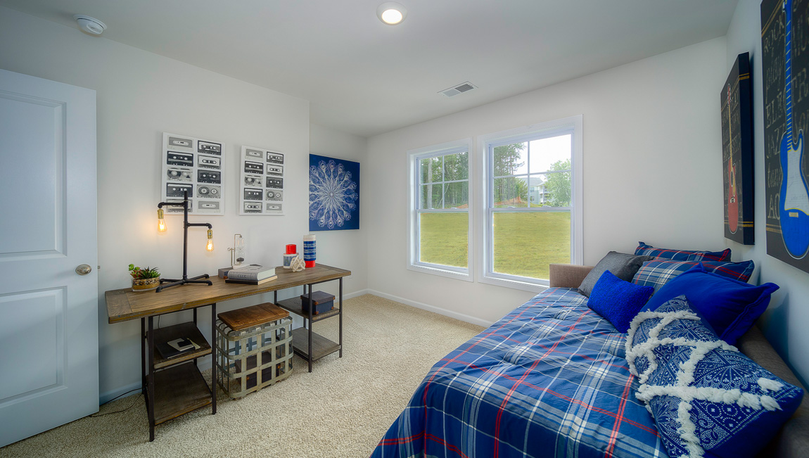 Carpeted bedroom with two small windows