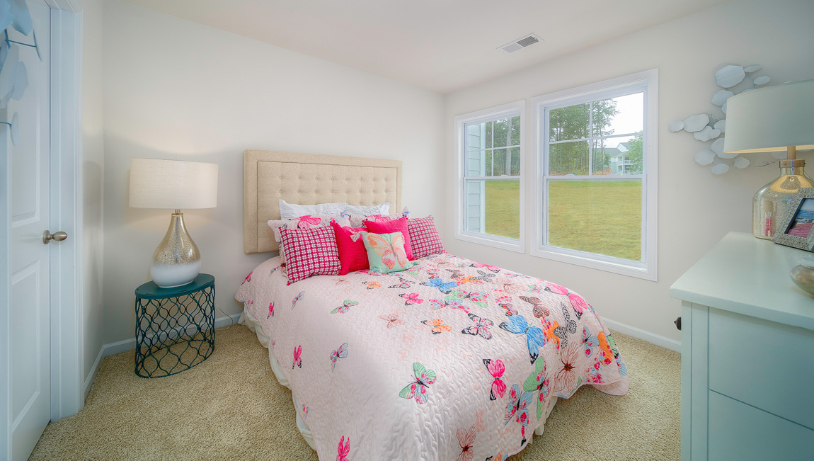 Carpeted bedroom with two small windows