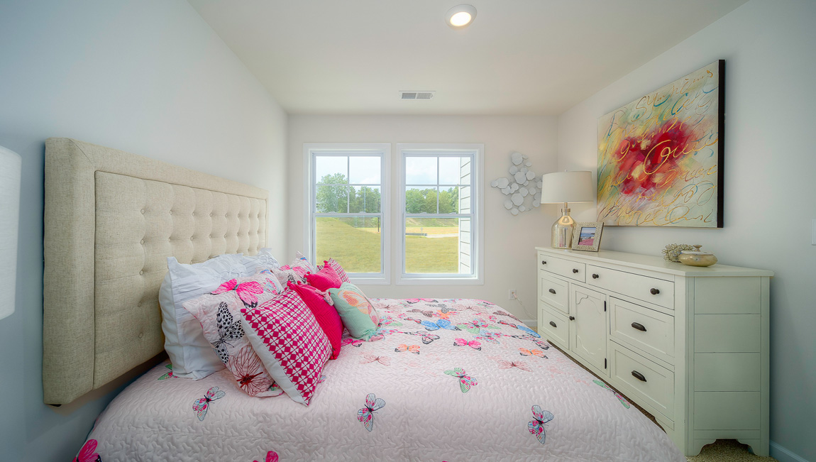 Carpeted bedroom with two small windows