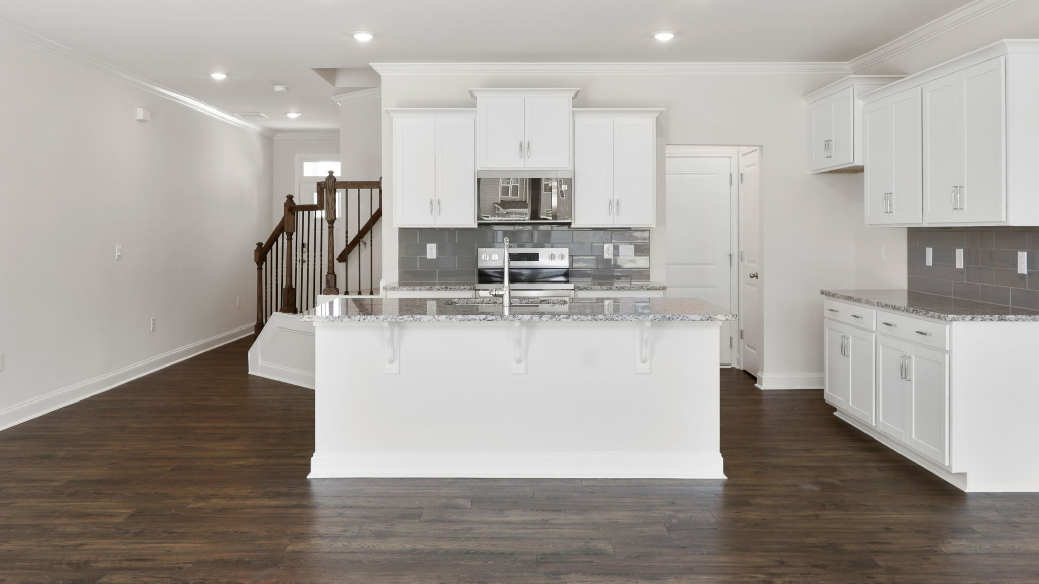 Open concept kitchen with white cabinets, large island and stainless steel appliances